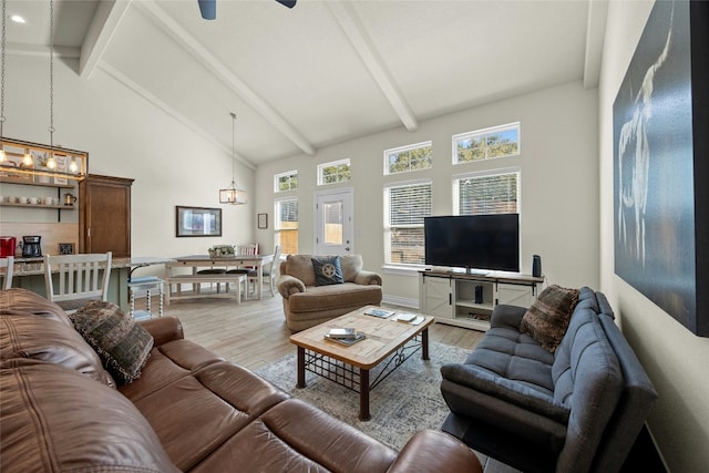 living area with high vaulted ceiling, a ceiling fan, beam ceiling, and light wood-style floors