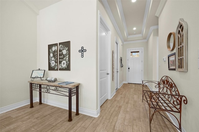 doorway featuring baseboards, light wood-style flooring, and crown molding