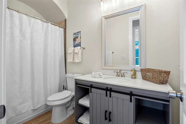 bathroom with wood finished floors, vanity, toilet, and shower / tub combo