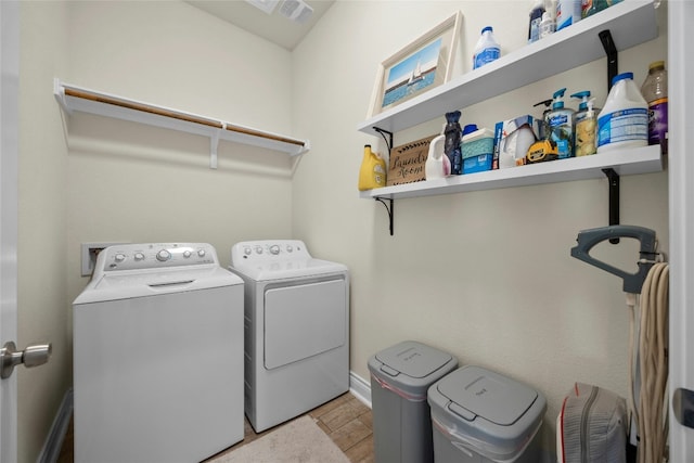 clothes washing area with washing machine and dryer, laundry area, and baseboards