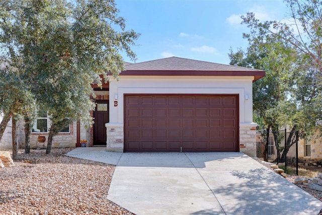 view of front of property featuring a garage, stone siding, and concrete driveway