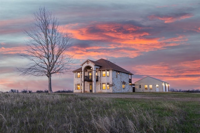 3622 N Fm 486, Thorndale, TX 76577 - french country home with a balcony, stone siding, a detached garage, and brick siding