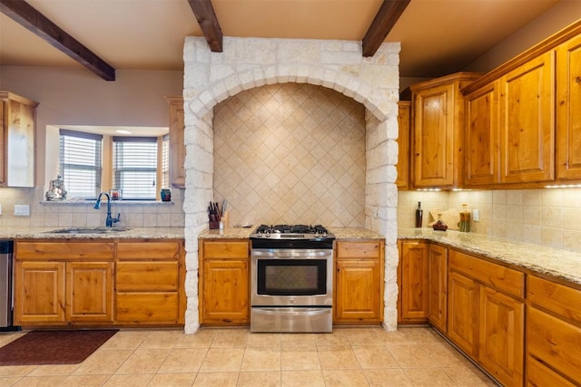 3622 N Fm 486, Thorndale, TX 76577 - kitchen featuring stainless steel gas stove, beam ceiling, backsplash, light tile patterned flooring, and brown cabinets