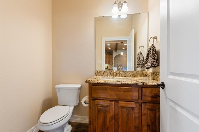 bathroom featuring baseboards, vanity, and toilet