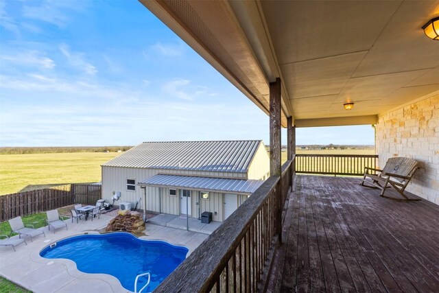 wooden deck featuring outdoor dining area, a fenced backyard, and a fenced in pool