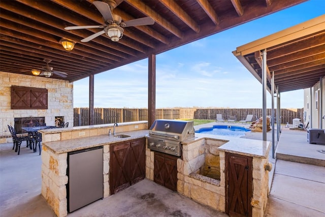 3622 N Fm 486, Thorndale, TX 76577 - fenced backyard featuring an outdoor kitchen, a bar, a patio, a ceiling fan, and an outdoor stone fireplace