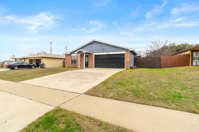 view of front of house with an attached garage, driveway, a front lawn, and brick siding