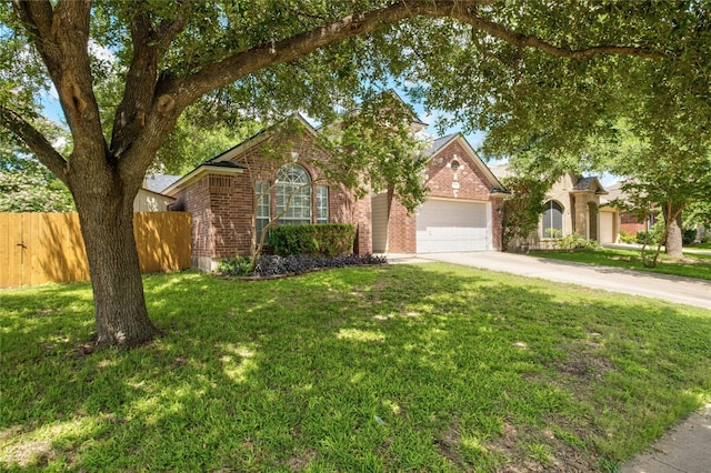 view of front facade with brick siding, concrete driveway, a front yard, fence, and a garage