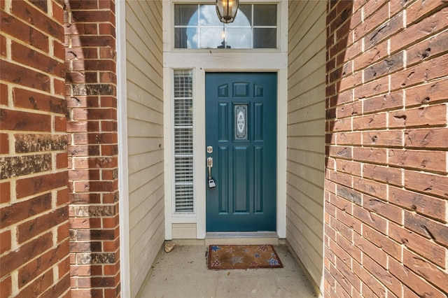 entrance to property featuring brick siding