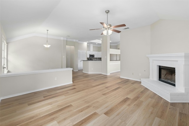 unfurnished living room with lofted ceiling, light wood finished floors, a fireplace, and visible vents