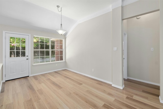 unfurnished dining area with lofted ceiling, baseboards, and light wood finished floors