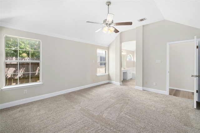 unfurnished bedroom with lofted ceiling, ensuite bathroom, carpet flooring, visible vents, and baseboards