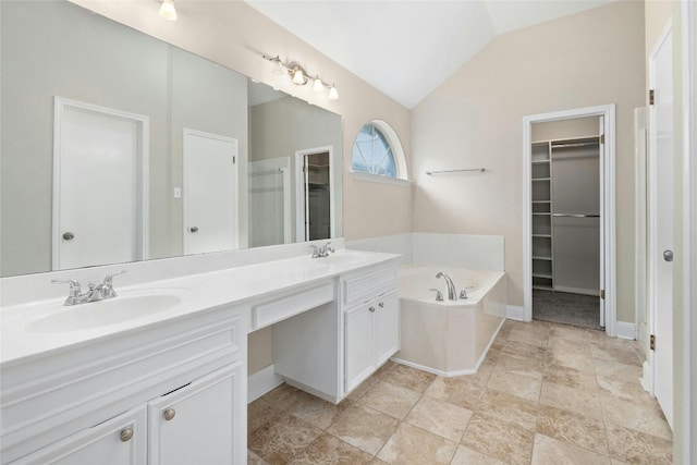 full bath with lofted ceiling, a spacious closet, a sink, and a bath