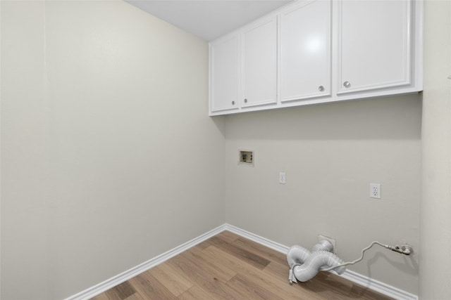 clothes washing area featuring cabinet space, hookup for a washing machine, baseboards, and light wood finished floors