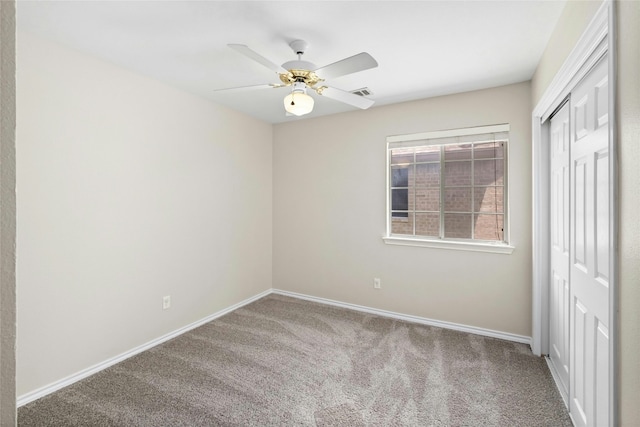 unfurnished bedroom featuring a ceiling fan, visible vents, baseboards, a closet, and carpet