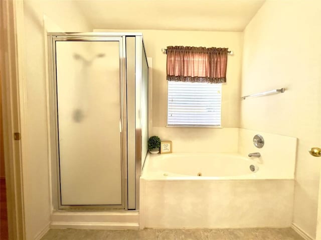 bathroom with a stall shower and a garden tub