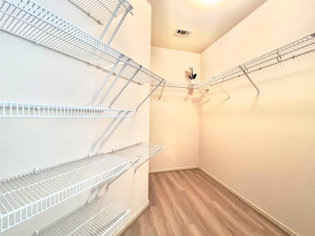 spacious closet featuring visible vents and wood finished floors