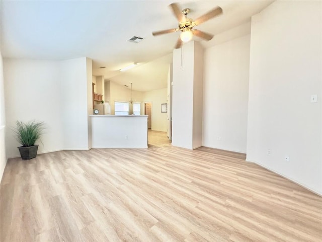 unfurnished living room with a ceiling fan, visible vents, vaulted ceiling, and light wood-style flooring