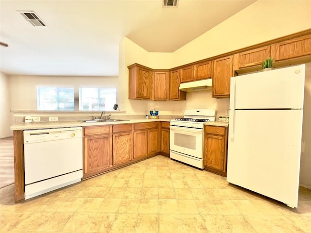 kitchen with brown cabinets, light countertops, a sink, white appliances, and under cabinet range hood