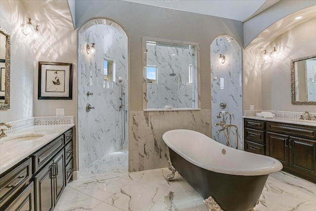 full bath featuring marble finish floor, a marble finish shower, two vanities, a sink, and a freestanding tub