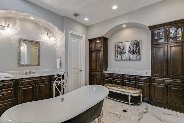 bathroom with a freestanding tub, recessed lighting, vanity, visible vents, and marble finish floor