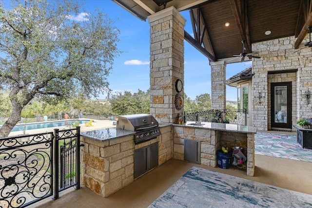 view of patio with an outdoor kitchen, a sink, fence, a grill, and an outdoor pool