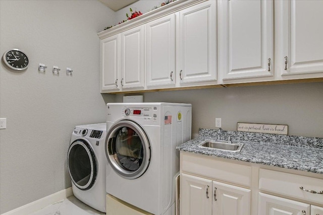 laundry area featuring cabinet space, baseboards, washing machine and clothes dryer, marble finish floor, and a sink