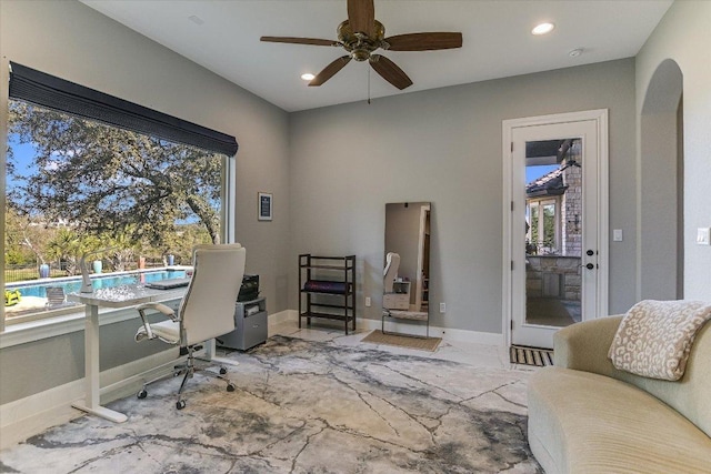 office space with plenty of natural light, baseboards, arched walkways, and recessed lighting