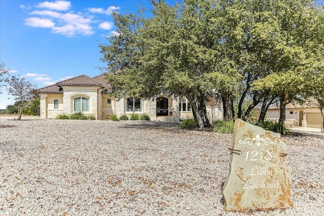 view of front of home with stone siding and a tile roof