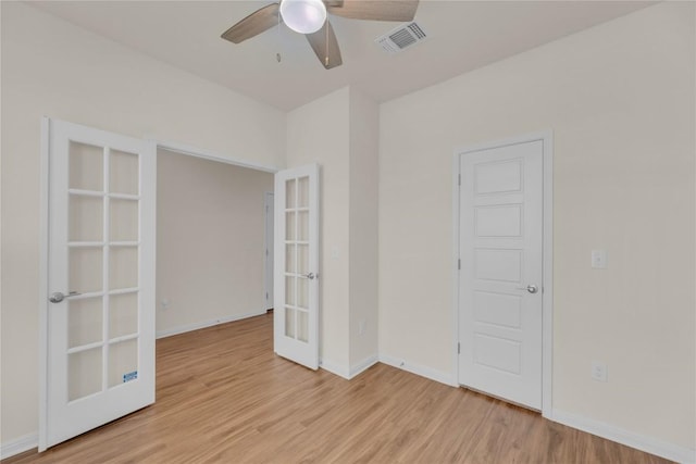 unfurnished room featuring french doors, visible vents, ceiling fan, and light wood-style flooring