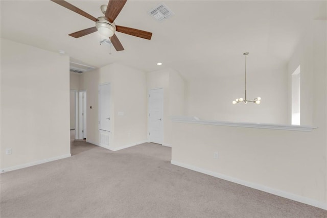 carpeted spare room with baseboards, visible vents, and ceiling fan with notable chandelier