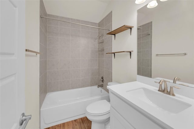 bathroom with washtub / shower combination, vanity, wood finished floors, and toilet