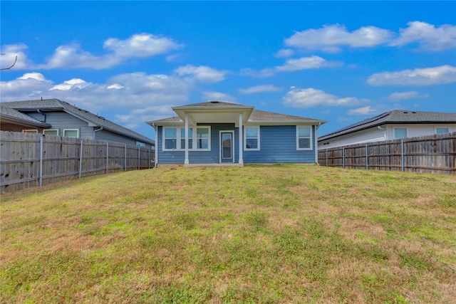 back of house featuring a fenced backyard and a yard