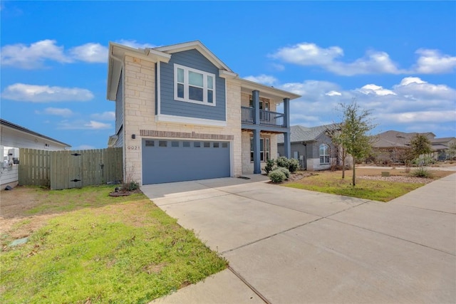 view of front facade with concrete driveway, a front yard, fence, a balcony, and a garage