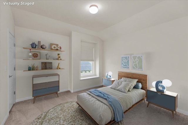 carpeted bedroom with lofted ceiling and baseboards