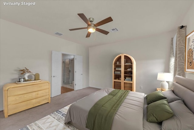 bedroom featuring a ceiling fan, visible vents, ensuite bath, and carpet flooring