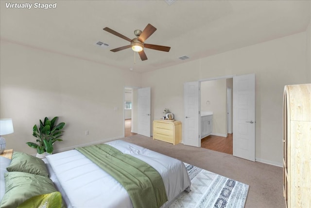 bedroom with baseboards, visible vents, connected bathroom, and light colored carpet