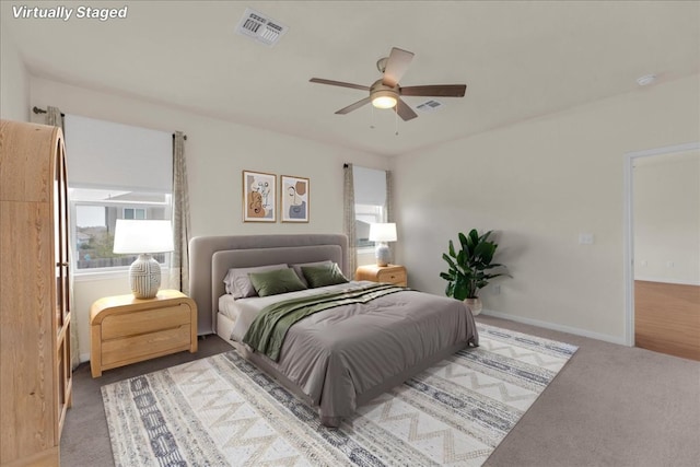 bedroom with carpet, visible vents, ceiling fan, and baseboards