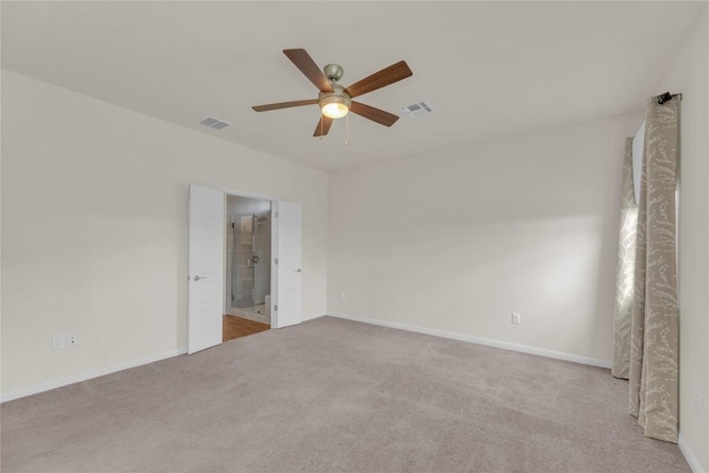 carpeted empty room featuring a ceiling fan, visible vents, and baseboards