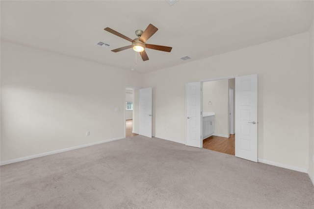 unfurnished bedroom featuring carpet floors, baseboards, visible vents, and connected bathroom