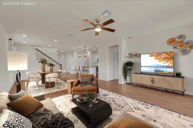 living area with a ceiling fan, visible vents, wood finished floors, and recessed lighting