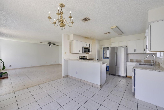 kitchen with stainless steel appliances, visible vents, open floor plan, light tile patterned flooring, and a sink