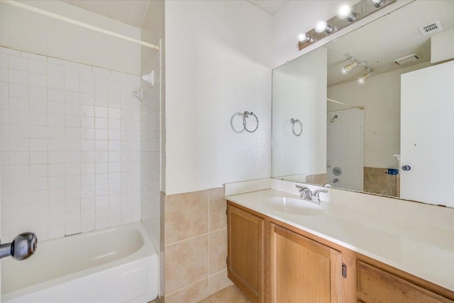 bathroom featuring shower / washtub combination, tile walls, visible vents, and vanity