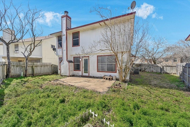 back of property with a yard, a chimney, a patio, central air condition unit, and a fenced backyard