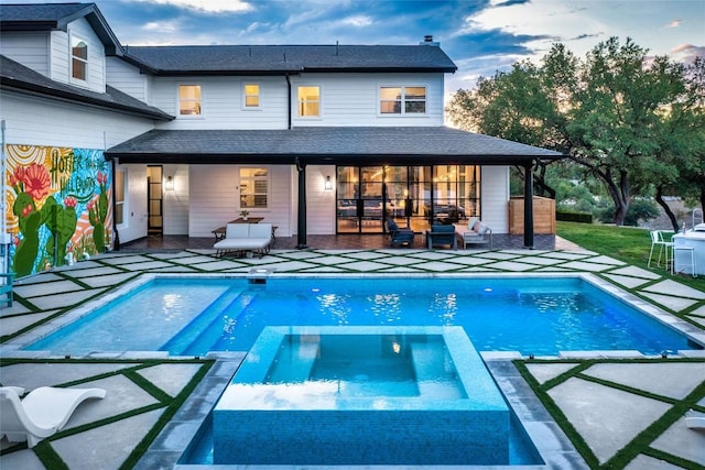 back of house with a patio, a shingled roof, and a pool with connected hot tub