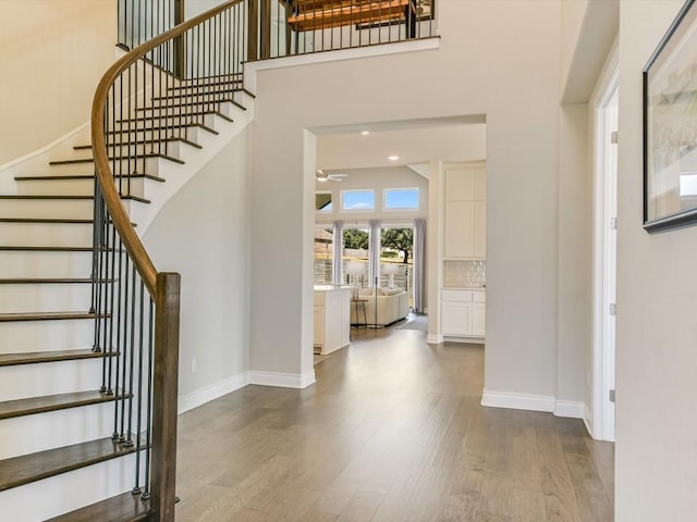 entrance foyer featuring a high ceiling, wood finished floors, and baseboards