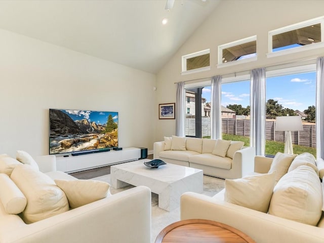 living area with ceiling fan and high vaulted ceiling