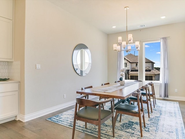 dining area with a chandelier, recessed lighting, wood finished floors, visible vents, and baseboards