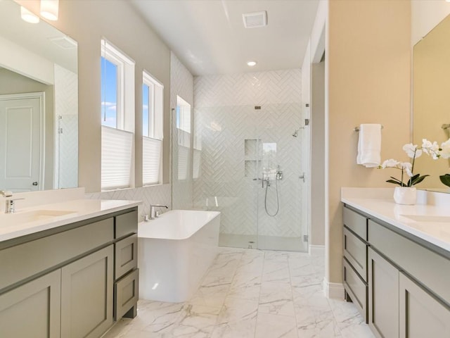 full bathroom with two vanities, a sink, marble finish floor, a soaking tub, and a stall shower