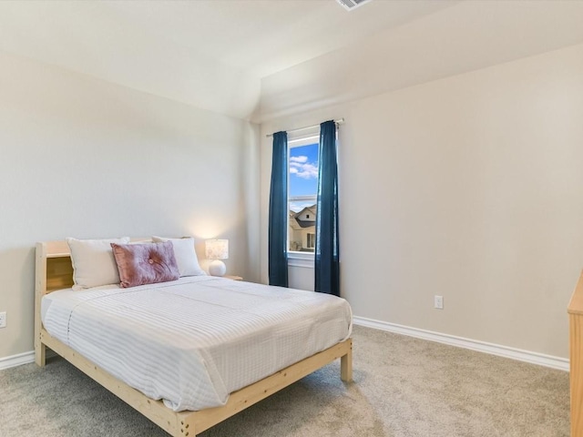 bedroom with carpet flooring, vaulted ceiling, and baseboards